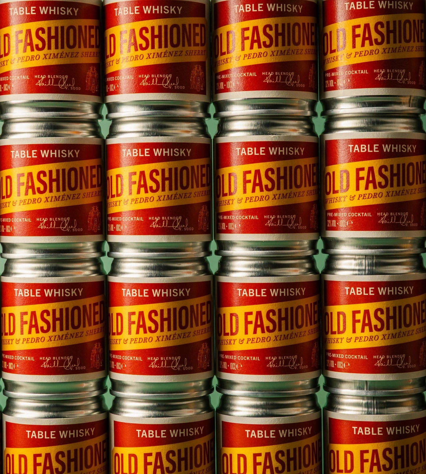 A tightly cropped view of stacked metal cans of Table Whisky, showing repeated labels that read "Table Whisky Old Fashioned, Whisky & Pedro Ximénez Pre-Mixed Cocktail".
